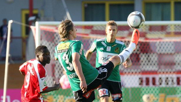 Ein Fußballspieler jongliert den Ball mit dem Fuß während eines Fußballspiels.