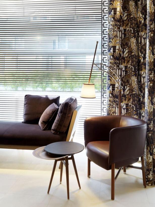 … Ein braunes Sofa, ein Sessel und ein Beistelltisch stehen in einem modern eingerichteten Raum.