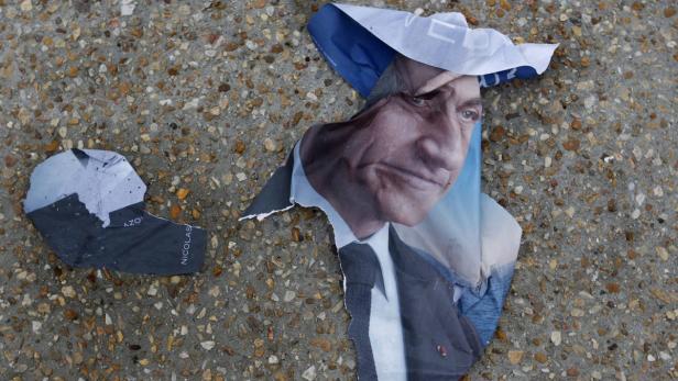 Ein zerrissenes Wahlplakat von Nicolas Sarkozy liegt auf dem Boden.