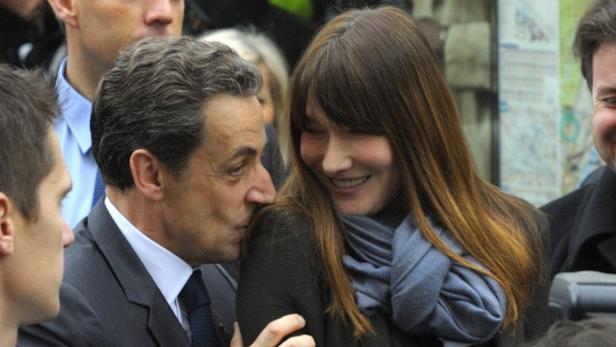 Nicolas Sarkozy gibt seiner Frau Carla Bruni einen Kuss auf die Wange.