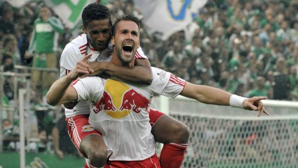 Zwei Fußballspieler von RB Salzburg feiern einen Sieg, einer trägt den anderen huckepack.