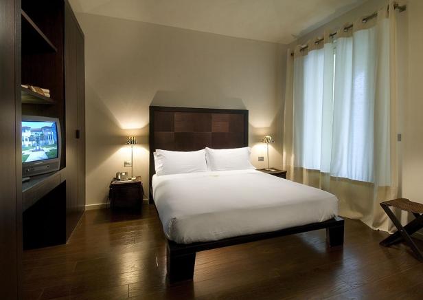 Ein Schlafzimmer mit einem Doppelbett, Nachttischen und einem Fernseher.