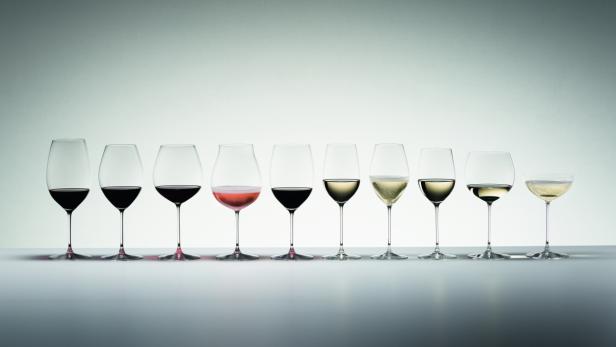 Eine Reihe von Weingläsern, gefüllt mit Rotwein, Roséwein, Weißwein und Sekt.
