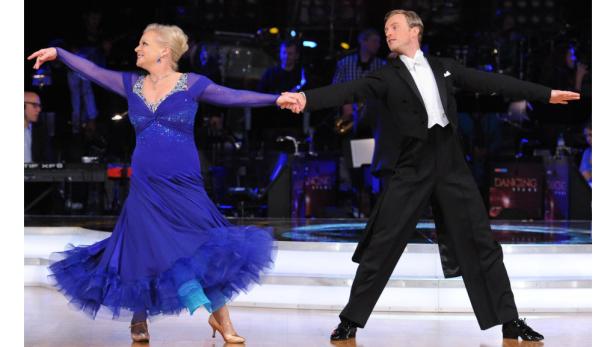 Ein Tanzpaar führt auf einer Bühne einen Standardtanz vor.