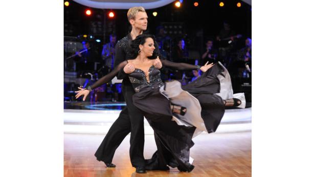 Ein Tanzpaar führt auf einer Bühne einen lateinamerikanischen Tanz auf.