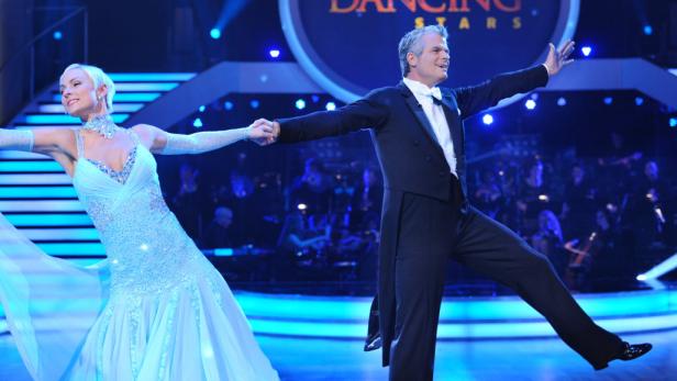 Ein Mann im Smoking tanzt mit einer Frau im hellblauen Kleid bei „Dancing Stars“.