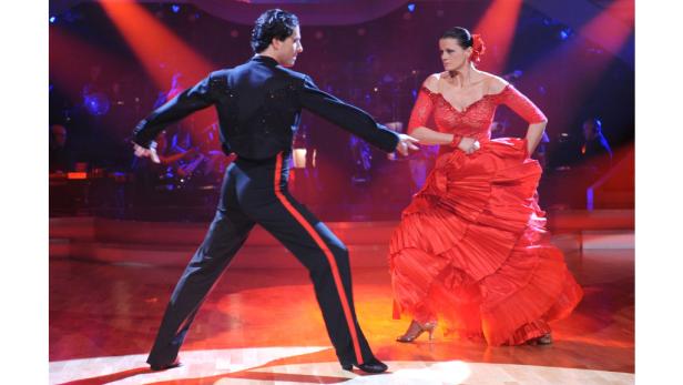 Ein Tanzpaar führt auf einer Bühne einen lateinamerikanischen Tanz auf.