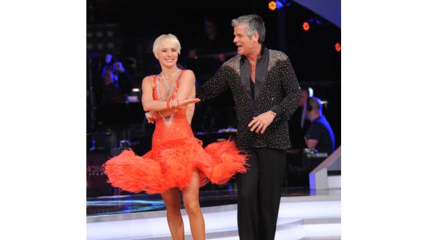 Ein Tanzpaar führt auf einer Bühne einen lateinamerikanischen Tanz auf.