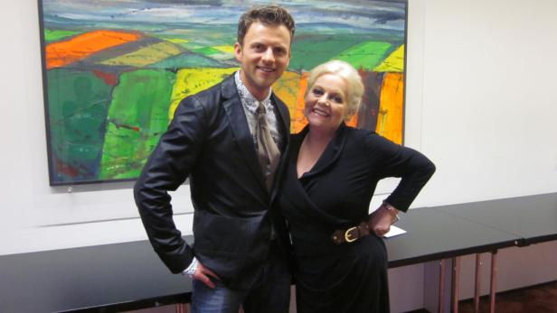 Ein Mann und eine Frau posieren vor einem abstrakten Gemälde.