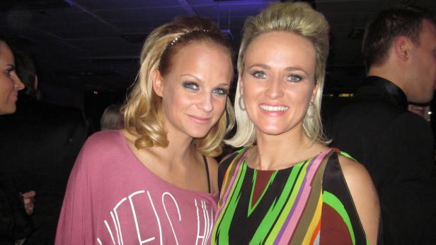 Zwei blonde Frauen posieren für ein Foto.