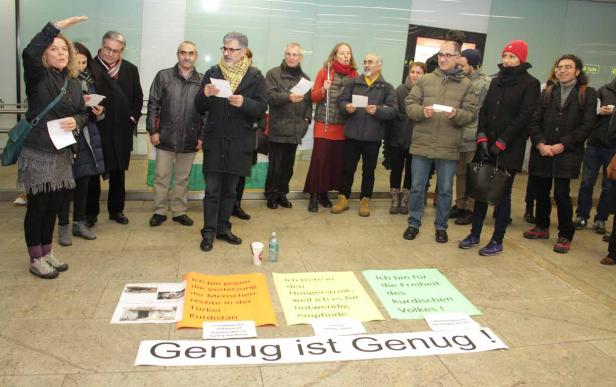 Eine Gruppe von Menschen demonstriert mit Schildern für die Rechte des kurdischen Volkes.