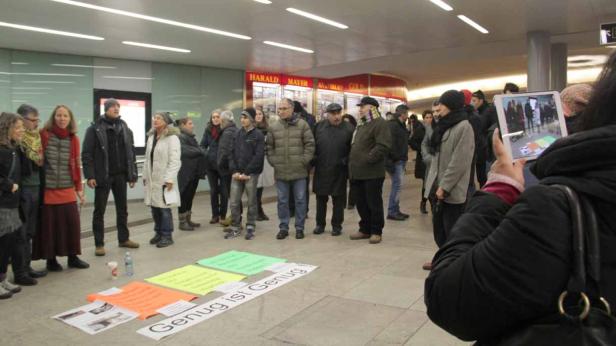 Eine Gruppe von Menschen steht um Schilder mit der Aufschrift „Genug ist Genug“.