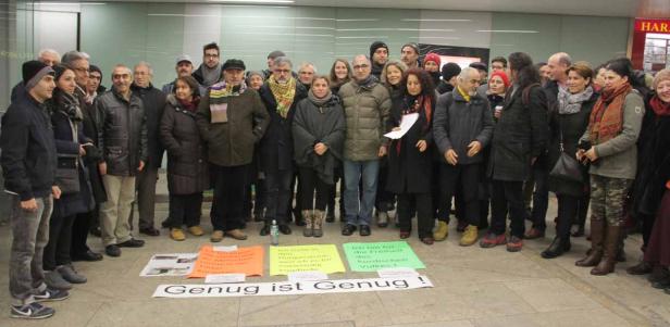 Eine Gruppe von Menschen demonstriert mit Schildern, auf denen „Genug ist genug!“ steht.