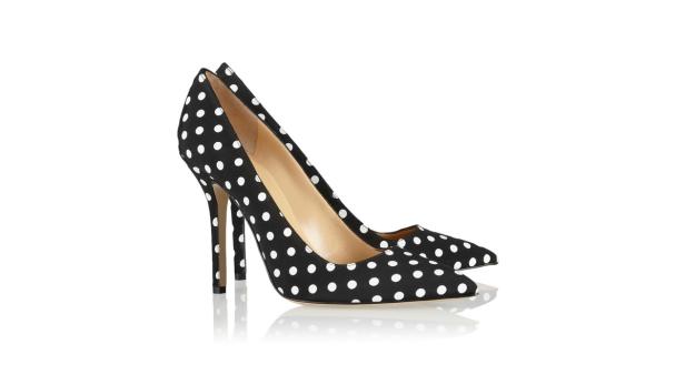 Ein Paar hochhackige Schuhe mit schwarzem Stoff und weißen Punkten stehen auf einem weißen Hintergrund.