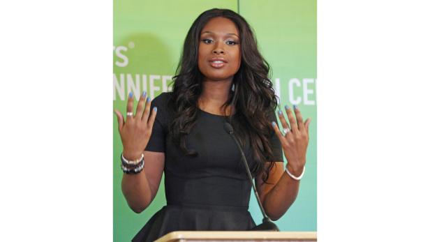 Jennifer Hudson spricht bei einer Veranstaltung vor einem grünen Hintergrund.