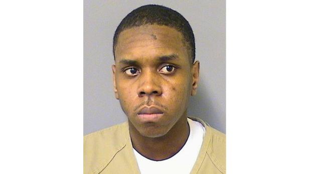 Ein Porträt eines jungen Mannes vor einem grauen Hintergrund.