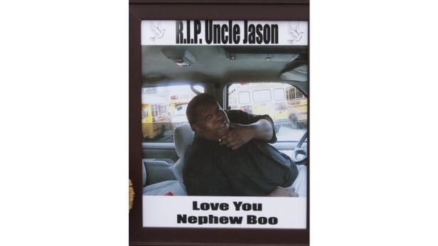 Ein gerahmtes Foto von Onkel Jason in einem Auto, mit Schulbussen im Hintergrund.