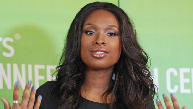 Jennifer Hudson posiert vor einem grünen Hintergrund.