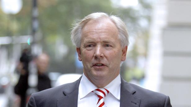 Gerhard Dörfler Ein Mann mit grauem Haar und rot-weiß gestreifter Krawatte geht die Straße entlang.