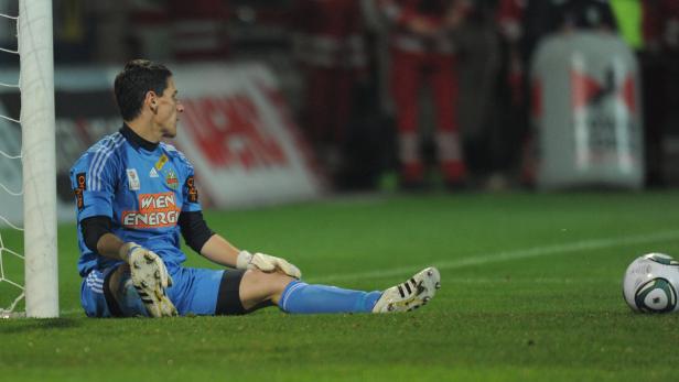 Ein Fußballtorwart sitzt während eines Spiels auf dem Rasen.