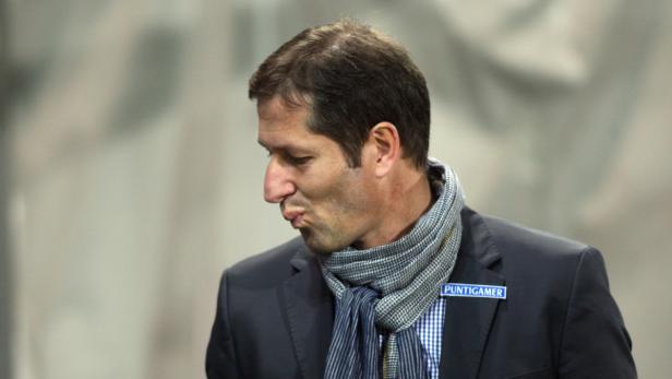 Ein Mann mit Schal und Anzug schaut zur Seite.