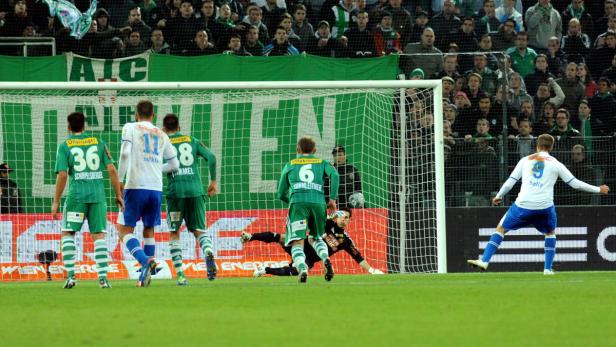 Ein Fußballspieler schießt einen Elfmeter auf das Tor.