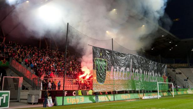 Fußballfans zünden im Stadion Bengalos und erzeugen Rauch.
