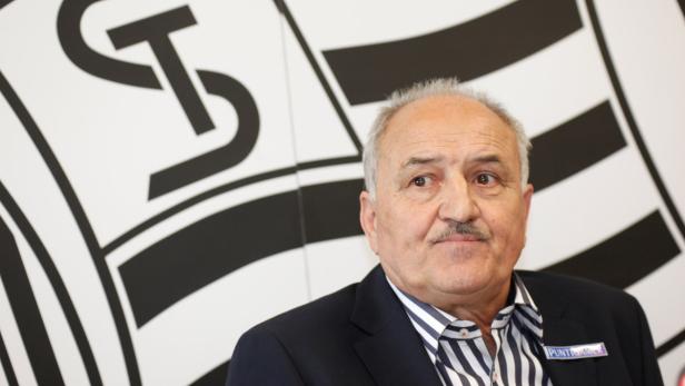 Ein Mann mit Schnurrbart vor einem schwarz-weißen Hintergrund mit dem Logo von Südtiroler Transportstrukturen.