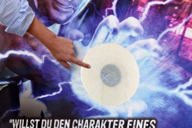 Sony - Playstation 3 - City Light-Kampagne - inFamous 2 - St. Stephens - OMD- Gewista Eine Hand deutet auf einen runden Aufkleber vor einem Hintergrund mit blauen Blitzen.