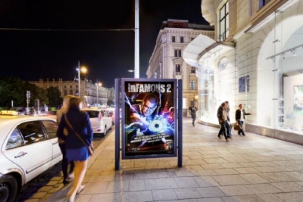 Sony - Playstation 3 - City Light-Kampagne - inFamous 2 - St. Stephens - OMD- Gewista Ein Werbeplakat für das Spiel „Infamous 2“ steht auf einem Bürgersteig in der Stadt.