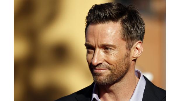 Ein Porträt von Hugh Jackman mit leichtem Bart und dunklem Haar.
