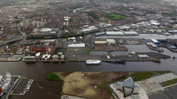 Luftaufnahme von Belfast mit Hafen, Stadt und einem Fährschiff.