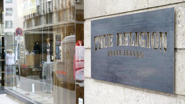 Das Schild des Bekleidungsgeschäfts „True Religion“ an einer Fassade.