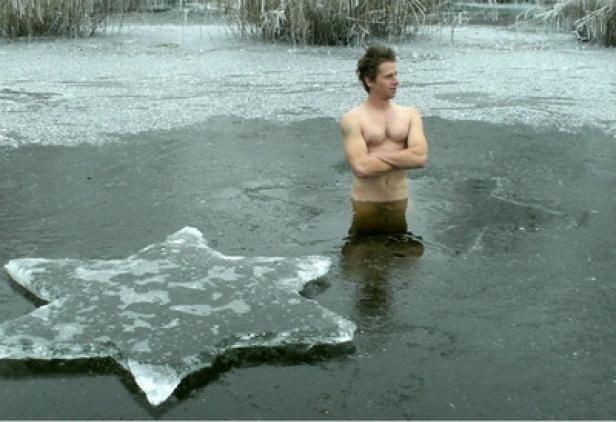 CastYourArt - Christian Eisenberger - Austria 9 Ein Mann steht barfuß in einem eisigen See, neben ihm ein großer Eisstern.