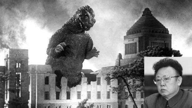Godzilla steht inmitten zerstörter Gebäude, im Hintergrund das japanische Parlamentsgebäude und Kim Jong-il.