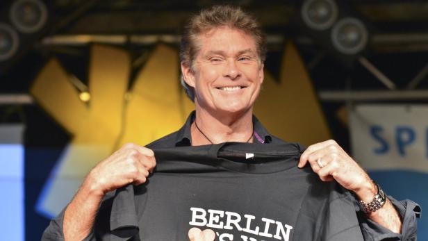 David Hasselhoff hält ein T-Shirt mit der Aufschrift „Berlin“ hoch.