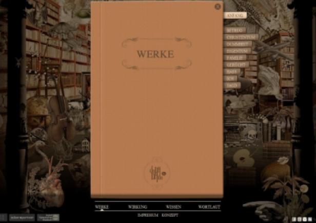 Ein aufgeschlagenes Buch mit dem Titel „Werke“ vor einem Bücherregal und verschiedenen Objekten.