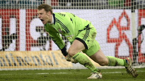 Ein Torwart in grüner Sportkleidung schreit auf dem Fußballfeld.