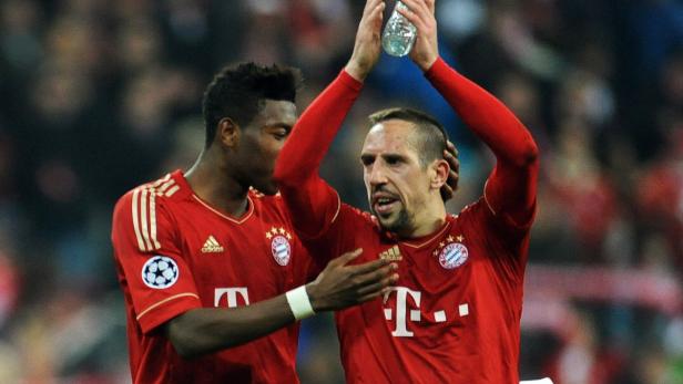David Alaba gratuliert Franck Ribéry mit einer Wasserflasche in der Hand.