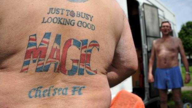 Ein Mann mit Tätowierungen auf dem Rücken, darunter der Schriftzug „Magic“ in den Farben der britischen Flagge.