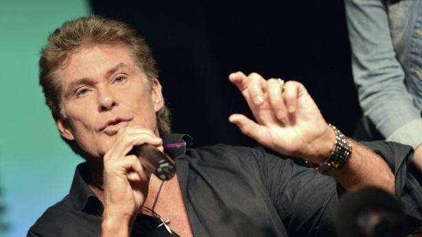 David Hasselhoff spricht in ein Mikrofon und gestikuliert mit der Hand.