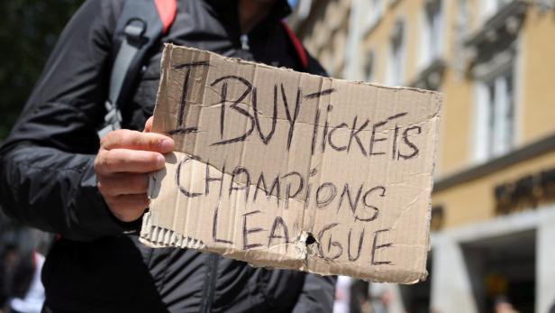 Eine Person hält ein Schild mit der Aufschrift „I BUY Tickets CHAMPIONS LEAGUE“.