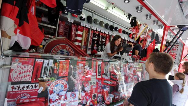 Eine Verkäuferin in einem Fanshop des FC Bayern München bedient einen Kunden.