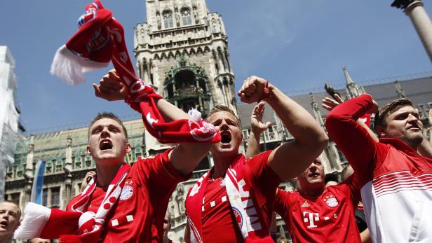 Jubelnde Fußballfans des FC Bayern München feiern vor dem Rathaus.
