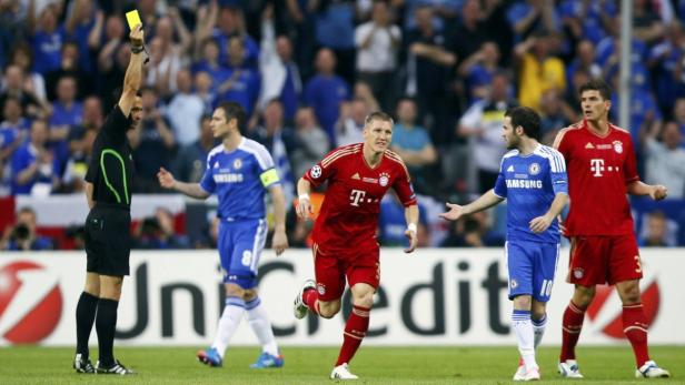 Ein Schiedsrichter zeigt Bastian Schweinsteiger während eines Fußballspiels die gelbe Karte.