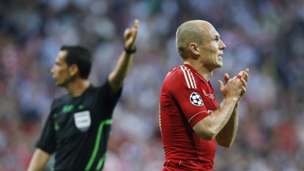 Arjen Robben klatscht während eines Fußballspiels, während ein Schiedsrichter im Hintergrund zu sehen ist.