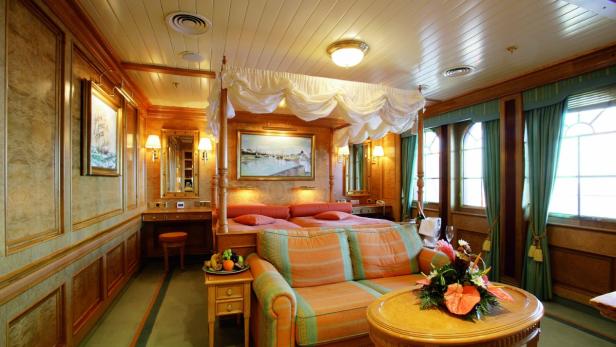 Ein luxuriöses Schlafzimmer mit Himmelbett und klassischer Einrichtung.