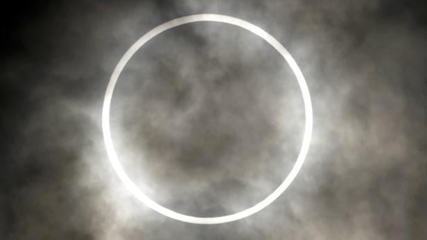 Eine ringförmige Sonnenfinsternis ist durch Wolken zu sehen.