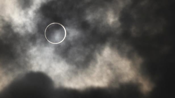 Eine ringförmige Sonnenfinsternis ist durch Wolken zu sehen.