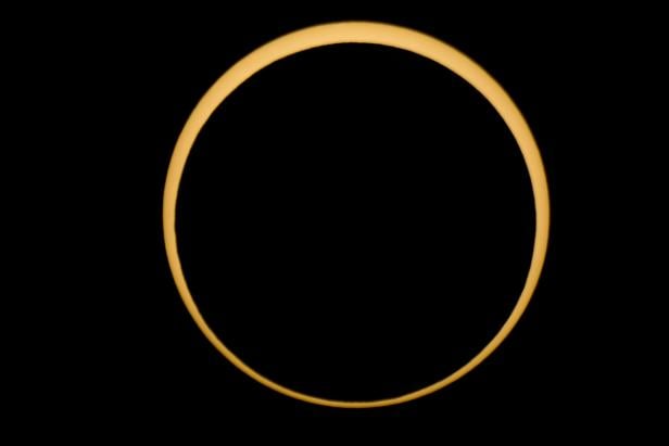 Eine ringförmige Sonnenfinsternis vor einem schwarzen Hintergrund.